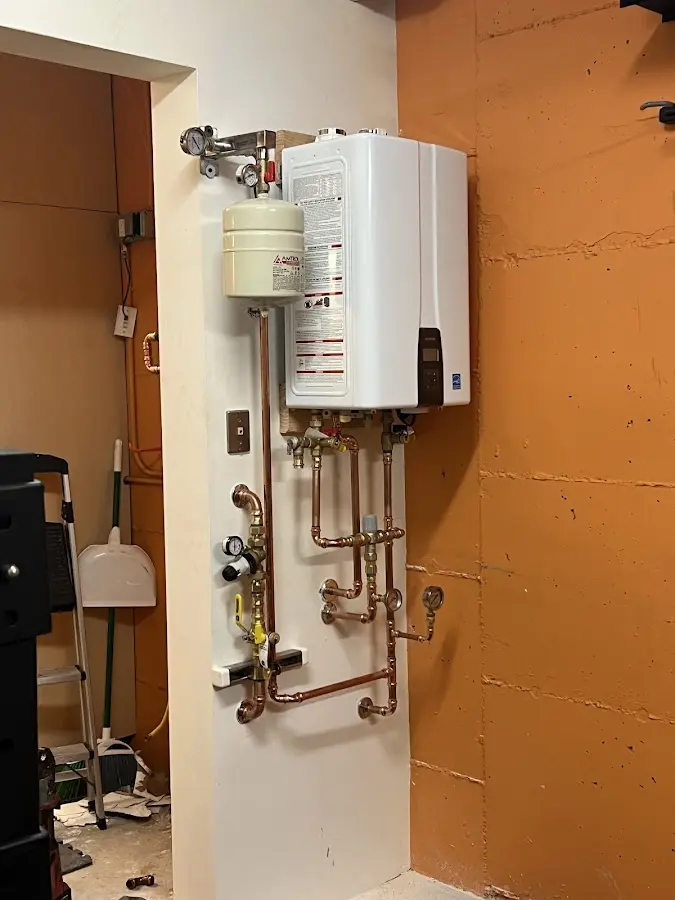 Plumbing technician inspecting water heater connections in Villa Park